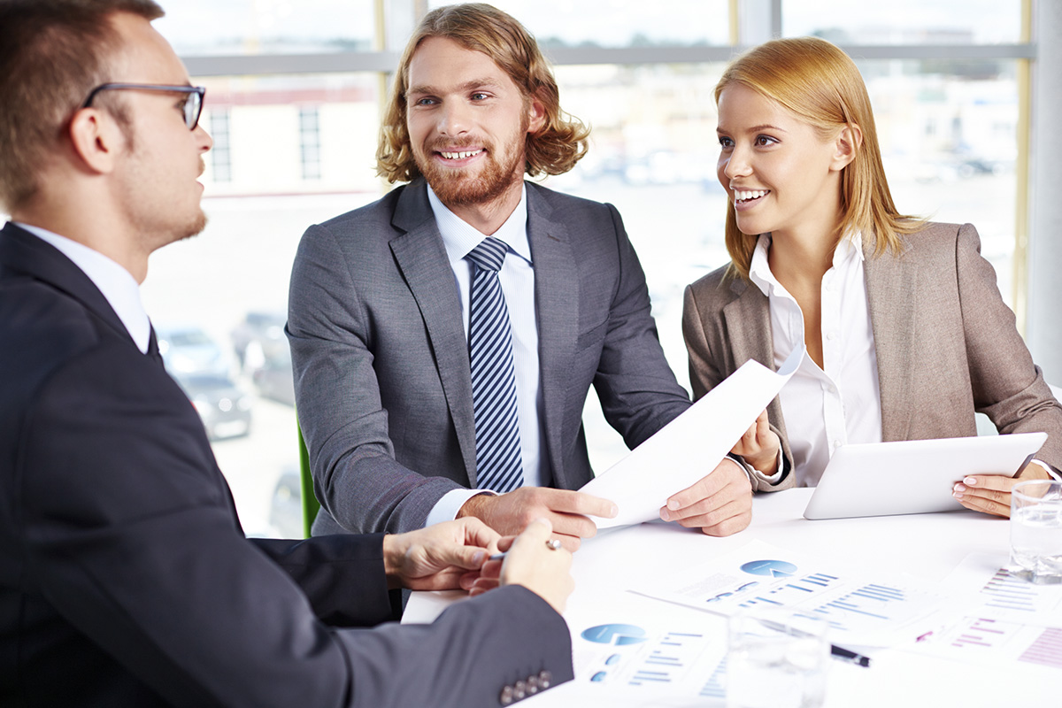 spotkanie biznsesowe trzech osób przy stole