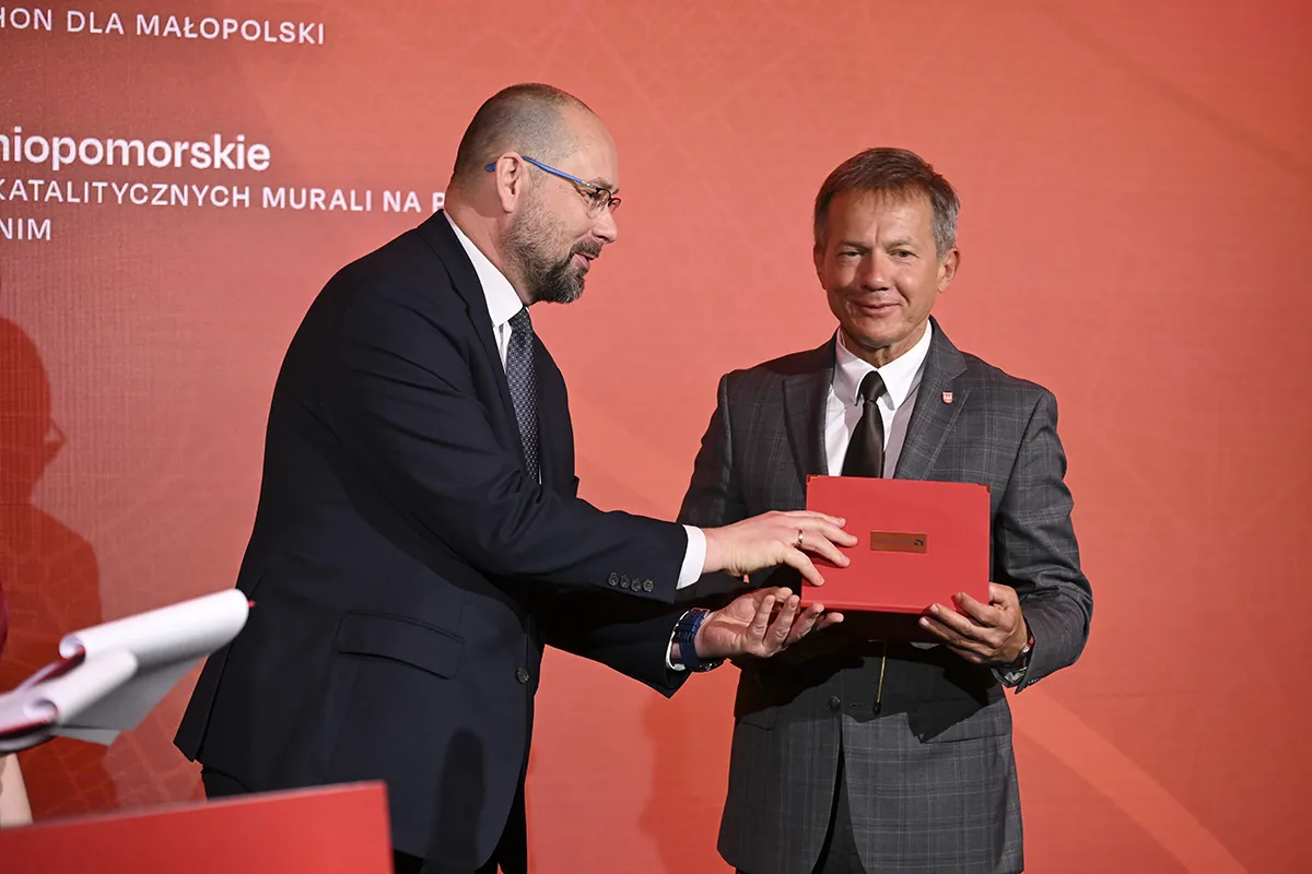 Mężczyzna w garniturze odbiera nagrodę